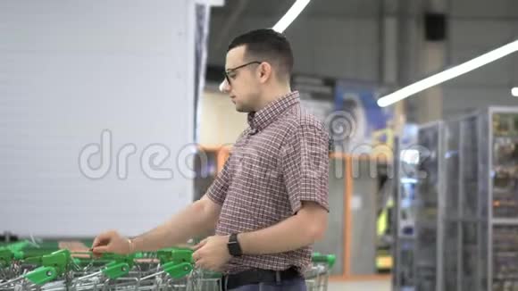 一个年轻人在超市里坐购物车购物和人的概念库存录像视频的预览图