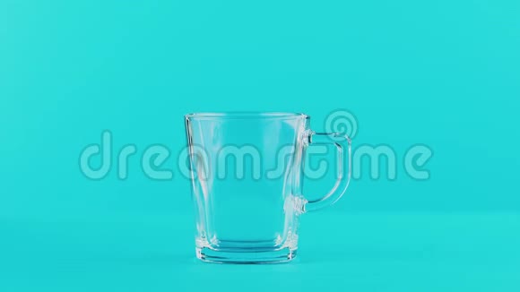 4K奶冷饮料的特写镜头在演播室里用蓝色背景的手柄缩成玻璃杯视频的预览图