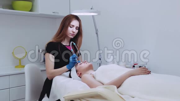 年轻的专业美容师为躺在床上的年轻女性患者做了一次皮肤恢复手术视频的预览图