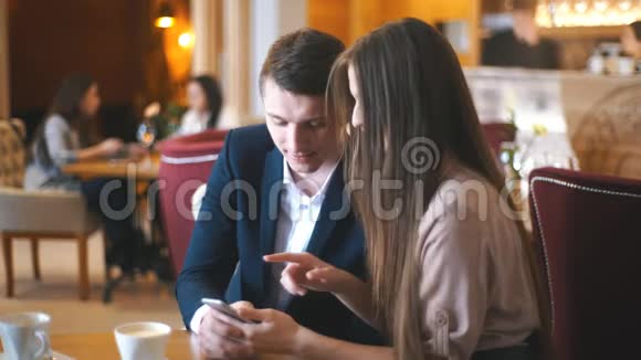 在咖啡馆用手机拥抱情侣视频的预览图