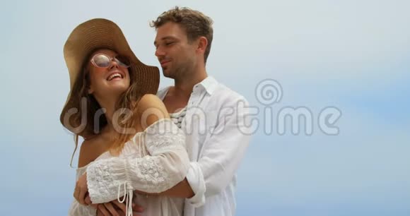 高加索夫妇在海滩上互相拥抱的侧面景色视频的预览图