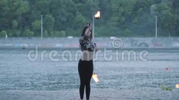 可爱自信的女人在森林或公园里用火焰表演节目熟练的火技艺术家展示视频的预览图