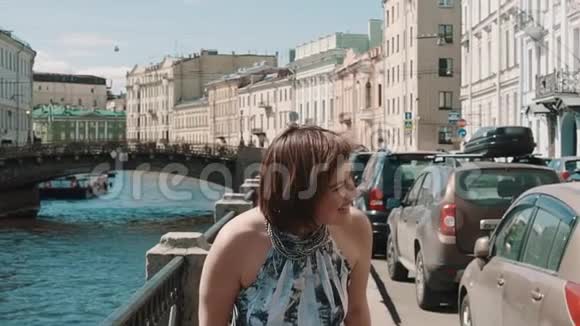 穿着斑点裙子的开朗女孩在旧市中心的堤岸笑视频的预览图
