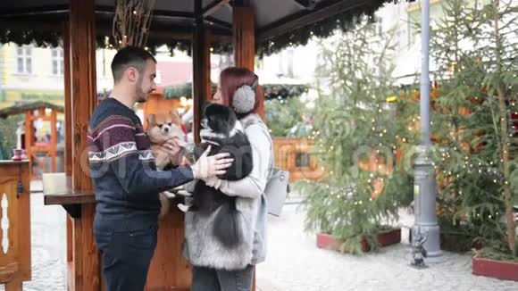 快乐的一对夫妇在户外玩得很开心圣诞节时间和新年快乐的概念情侣们抱着可爱的狗视频的预览图
