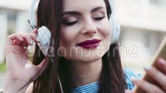 近距离观看一个迷人的迷人的黑发女孩红唇和鼻子穿着白色的音乐视频的预览图