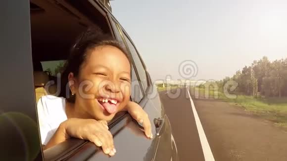 无牙女孩在车窗上挥舞双手视频的预览图