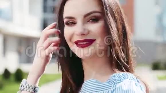 近距离观看漂亮的黑发女人她涂着鲜红的口红鼻子穿着可爱的微笑朝镜头走来视频的预览图