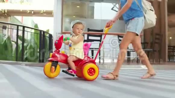 妈妈在暑假散步时骑着小女儿骑着儿童自行车视频的预览图