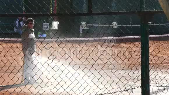 维修人员在网球场浇水工人用水喷洒网球场视频的预览图
