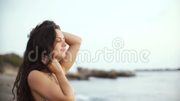穿着比基尼的年轻黑发女子望着远方在海底做梦视频的预览图