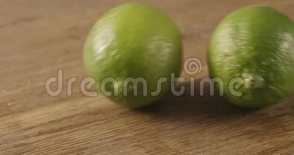两个绿柠檬卷在木桌上视频的预览图