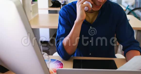 男性高管在办公桌前工作时会用手机说话视频的预览图