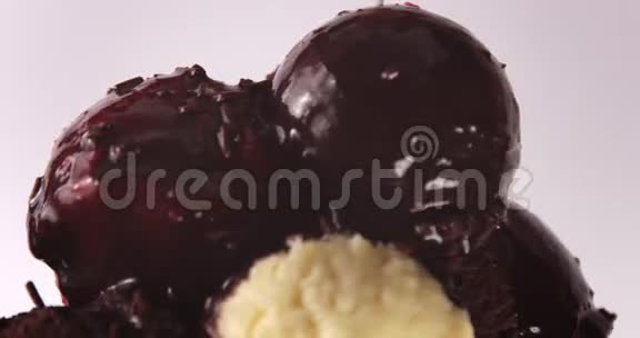 巧克力覆盖的冰淇淋球的特写和彩色装饰落在上面视频的预览图