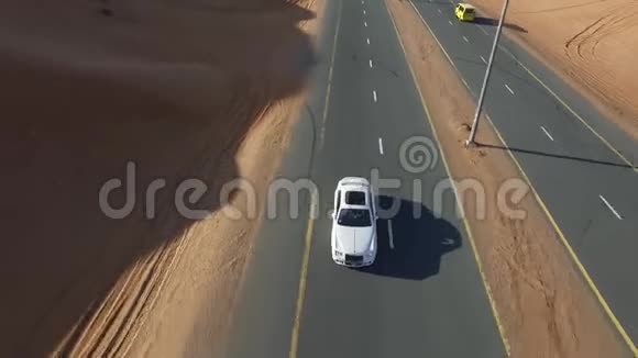 白色克莱斯勒的正面景色沿着一条沙漠之路向前延伸视频的预览图
