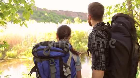 两个背包游客欣赏湖景视频的预览图