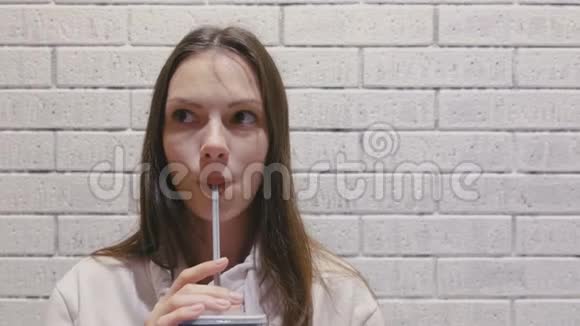 微笑美丽的女人正从管子里喝饮料视频的预览图