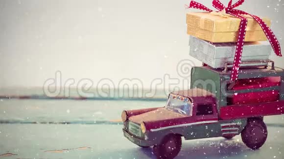 屋顶上有圣诞礼物和降雪的模型车视频的预览图