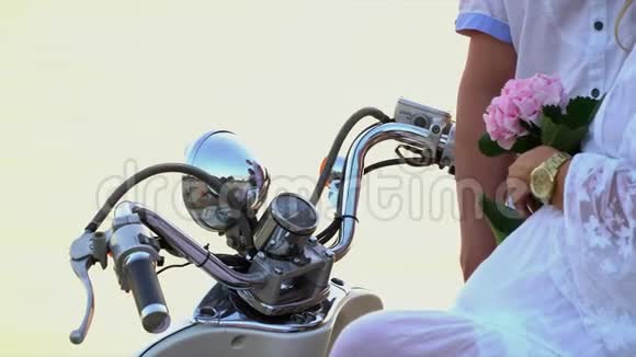 把白色摩托车的轮子关上那个女人和那个男人坐在海滨一个亲密的大家庭休息一下视频的预览图