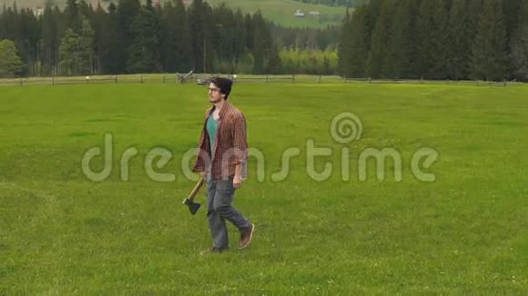 有斧子的人正走在山野上视频的预览图