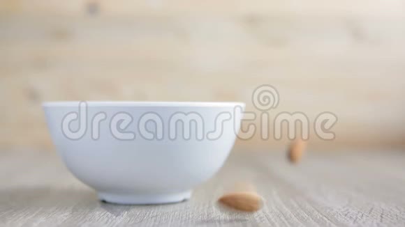 生杏仁倒在木桌上的碗里视频的预览图