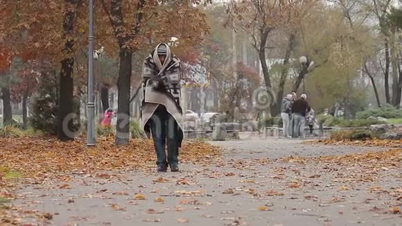 可怜的穷人在城市公园里散步浑身是冰冷的破旧毯子视频的预览图