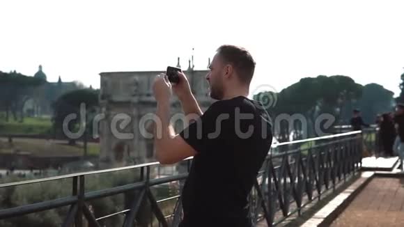 人类游客在意大利罗马的智能手机上拍摄风景照片康斯坦丁的拱门在背景上慢动作视频的预览图