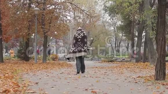 奇怪的人在城市公园里游荡身上盖着毯子精神病患者视频的预览图