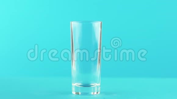 慢动作特写镜头果橙多果汁冷饮饮料变低玻璃蓝色背景在视频的预览图