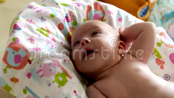 美丽的小女孩微笑着躺在婴儿床上视频的预览图