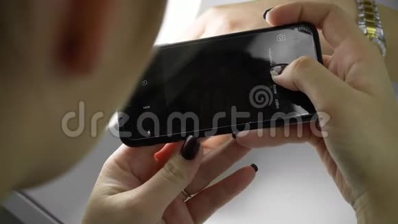 女人用手拍她新修指甲的照片手机上有时尚珠宝女孩的东西概念视频的预览图