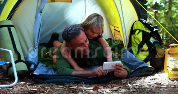 父子俩在帐篷外用手机视频的预览图