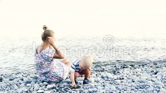 快乐的妈妈和她的孩子在海滩上视频的预览图