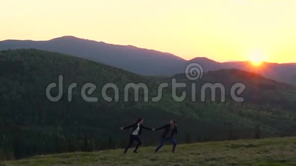 一对夫妇在山上与夕阳赛跑视频的预览图
