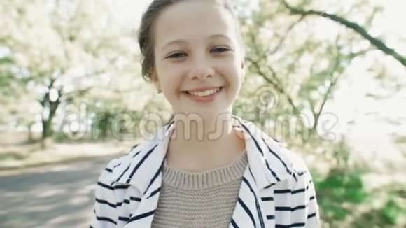 一个年轻微笑的女孩的特写肖像一个甜美的女孩看着相机笑视频的预览图