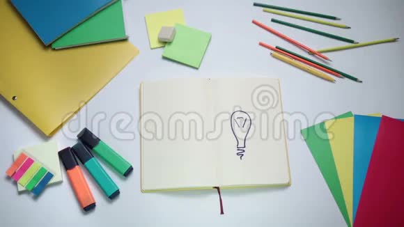 女孩子在灯泡上面的记事本上写字视频的预览图