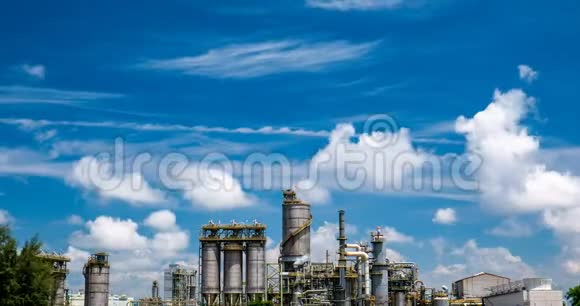 排在树后面的炼油厂和蓝天上的云视频的预览图