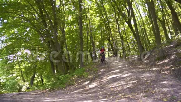 在一个寒冷的日子里年轻人骑着自行车在森林道路上视频的预览图