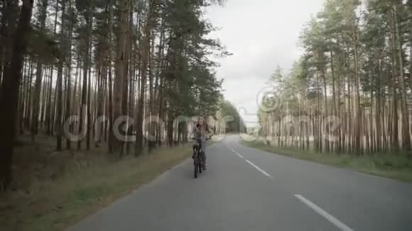 金发女郎骑自行车漂亮的年轻女孩在高速公路上骑自行车视频的预览图