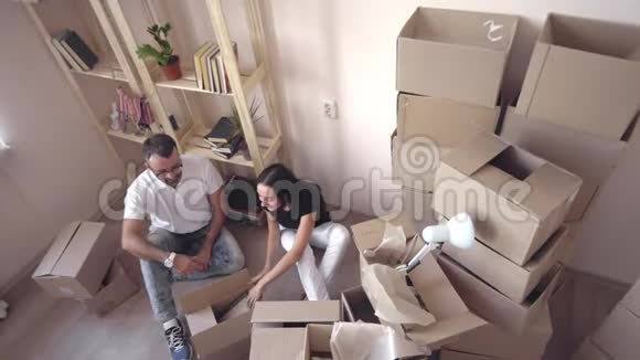 年轻夫妇轻松地搬进了一所新房子里面有未包装的盒子视频的预览图