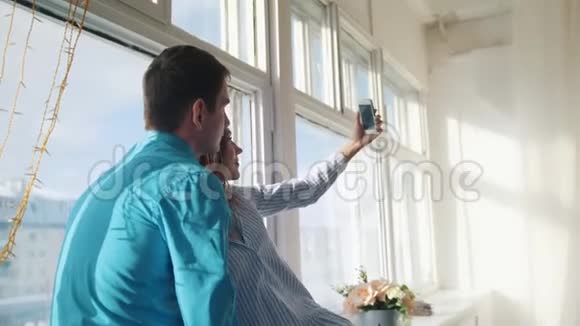 幸福快乐的情侣在窗户上自拍年轻迷人的男女视频的预览图