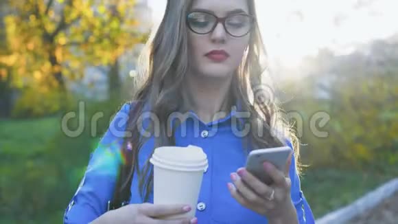漂亮的商务小姐打电话喝咖啡在公园4K微笑视频的预览图