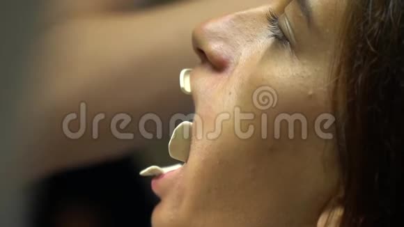 口腔检查中口部扩张器年轻女性的特写牙科诊所的一个年轻女孩视频的预览图