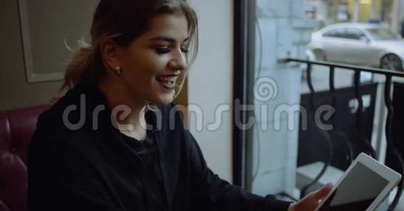 咖啡馆里有平板电脑的美丽快乐的女人的肖像4k慢动作视频的预览图