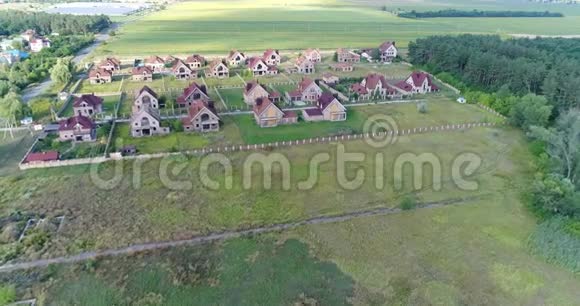 未完成的小屋废弃的小屋一个小镇几栋房子绿色草坪从上面看空中视频的预览图