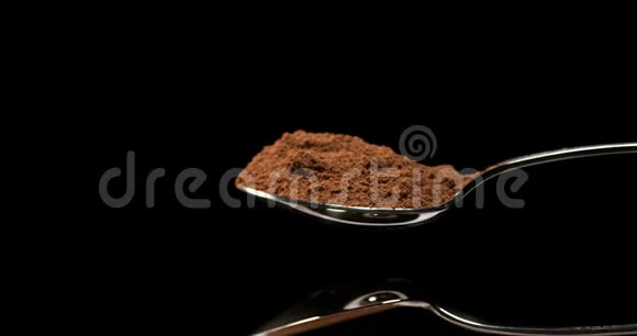 肉豆蔻肉豆蔻粉末落在黑色背景下慢运动视频的预览图