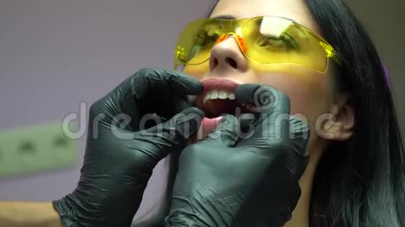 特写一位戴黄镜的病人的肖像戴黑色手套在牙医那里接受牙科检查病人视频的预览图