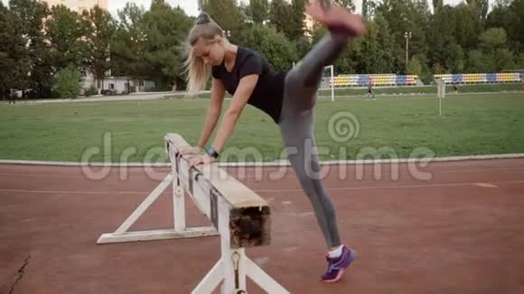 年轻女孩在训练前揉捏运动员把苍蝇腿靠在一边视频的预览图