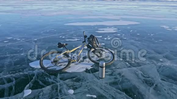人和他的自行车在冰上他看着裂缝里美丽的冰第一人称观点骑自行车的人穿着视频的预览图