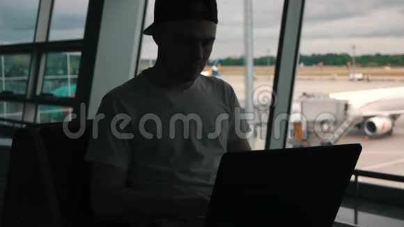 这个人正在机场候机楼用笔记本电脑工作视频的预览图
