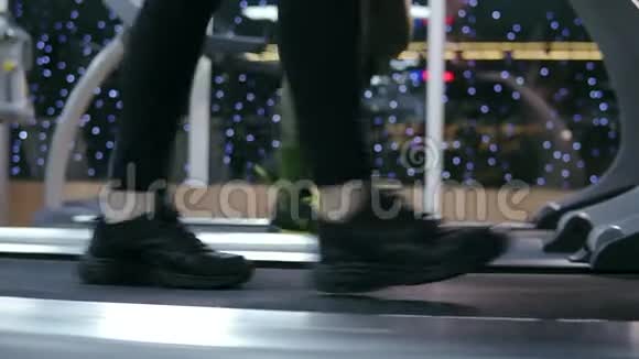 在健身房的跑步机上行走的运动健将的脚的侧面特写镜头在热身前视频的预览图